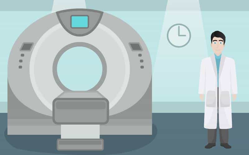 Doctor standing next to CT scanner